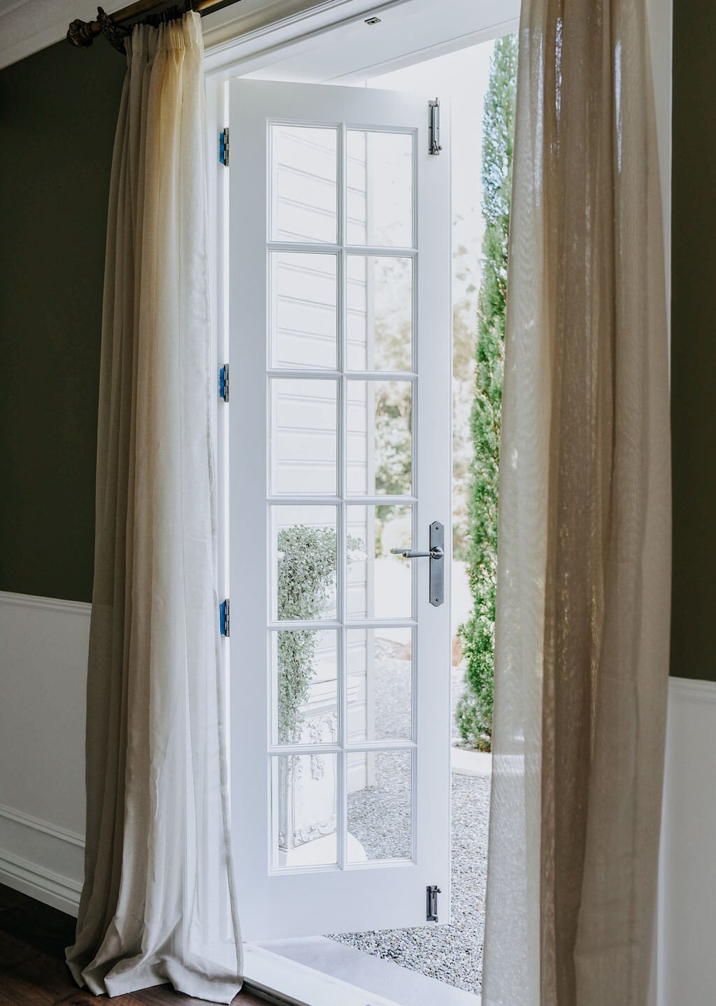 These gorgeous white french doors of The Grounds Estate feature the Reims Lever on Long Backplate in Antique Copper.