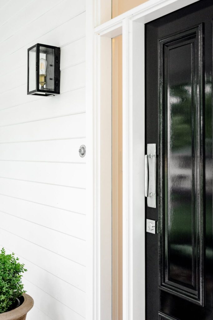 The exterior door of the Swift Family Homestead features the Bell Press that contrasts beautifully with the striking black door.