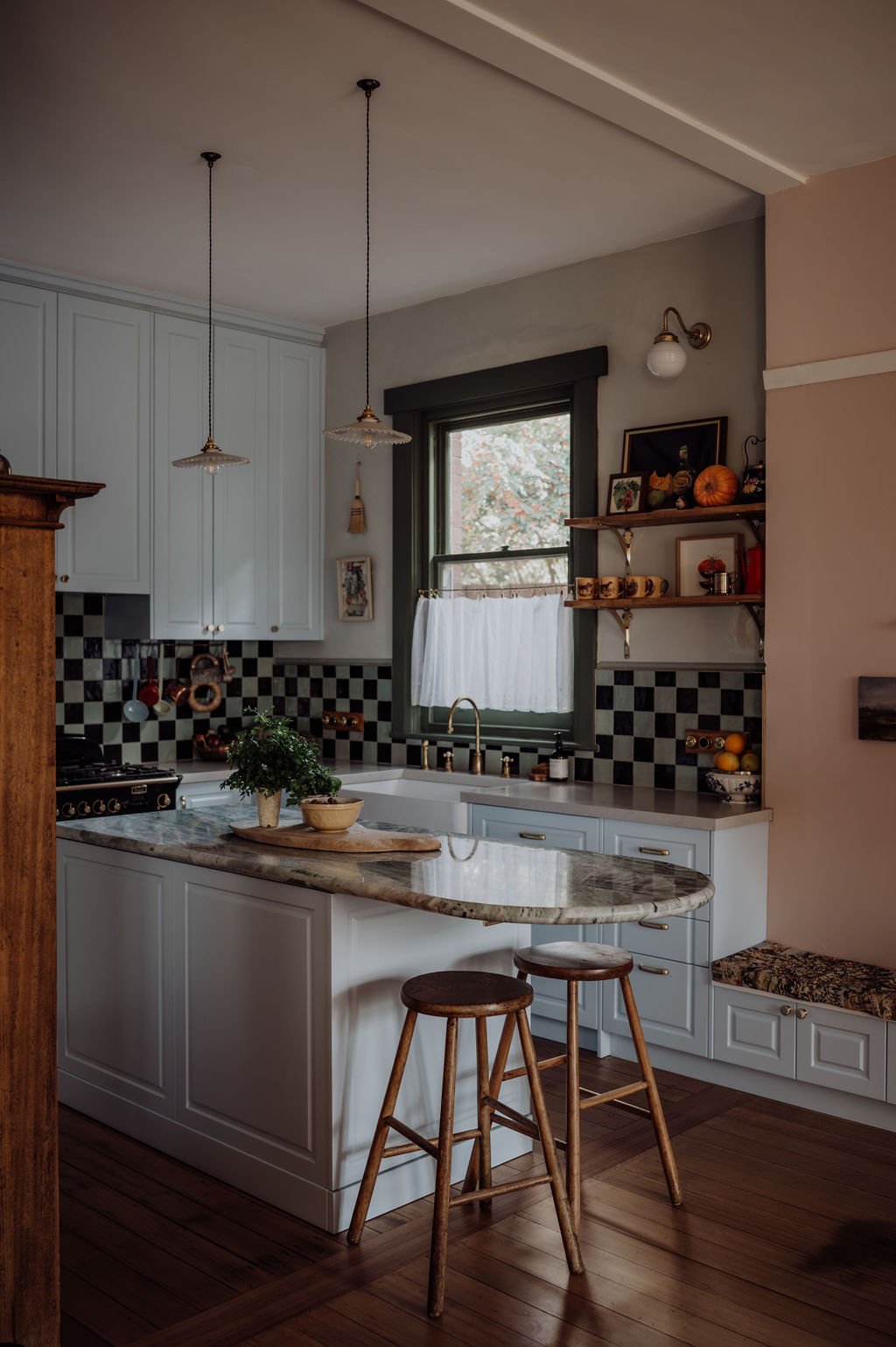 The Californian Bungalow kitchen incorporates white cabinetry, marble benchtops and a checkered splashback. The kitchen features TradCo's Deco Cabinet Pull Handles & Shelf Brackets.