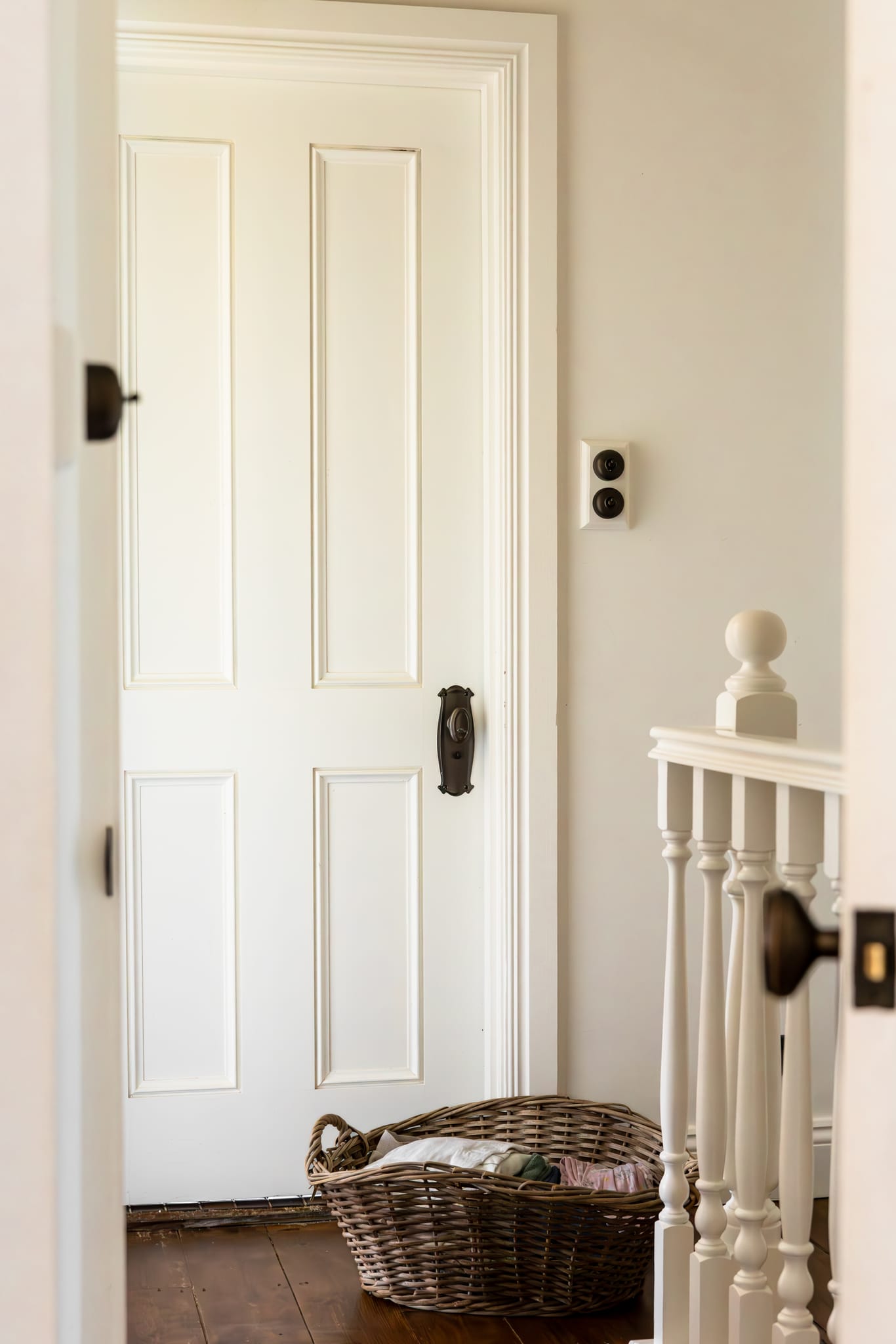 Aged brass door hardware and light switch in a restored hallway