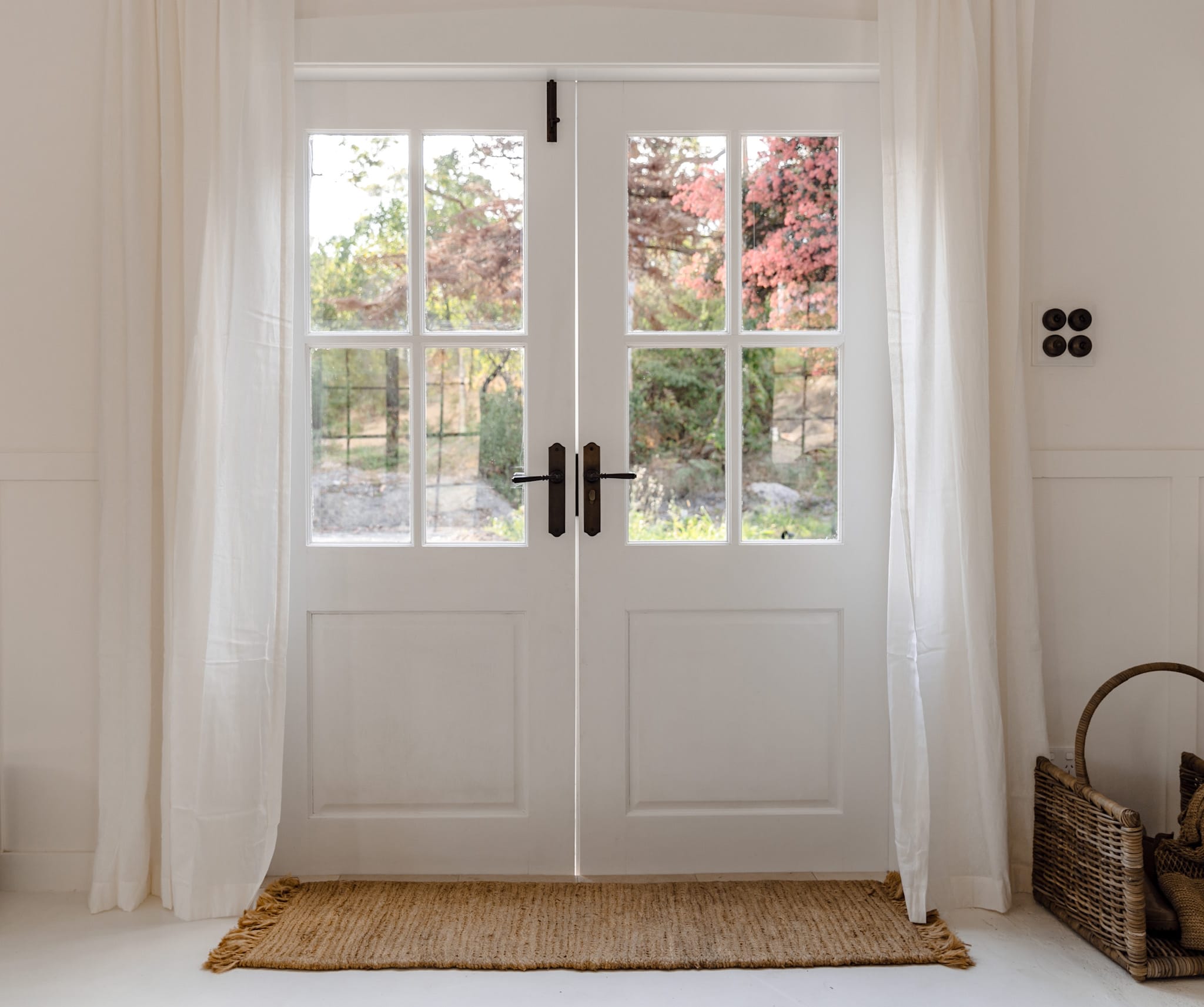 Interior french doors with dark bronze lever handles and a heritage toggle switch