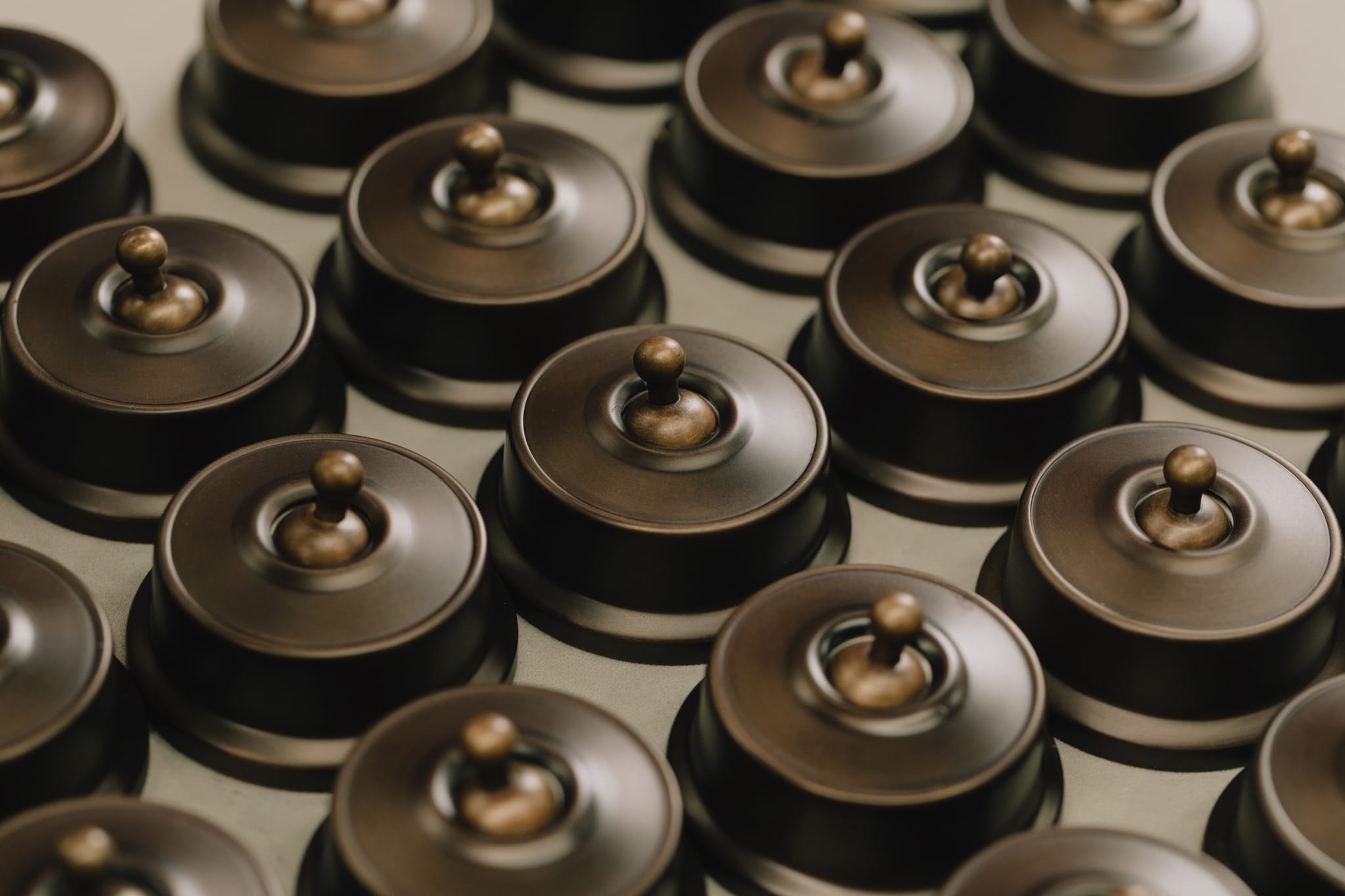 Rows of antique brass toggle light switches on the bench