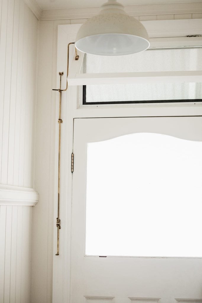 Brass fanlight window operator fitted to a fanlight above a door