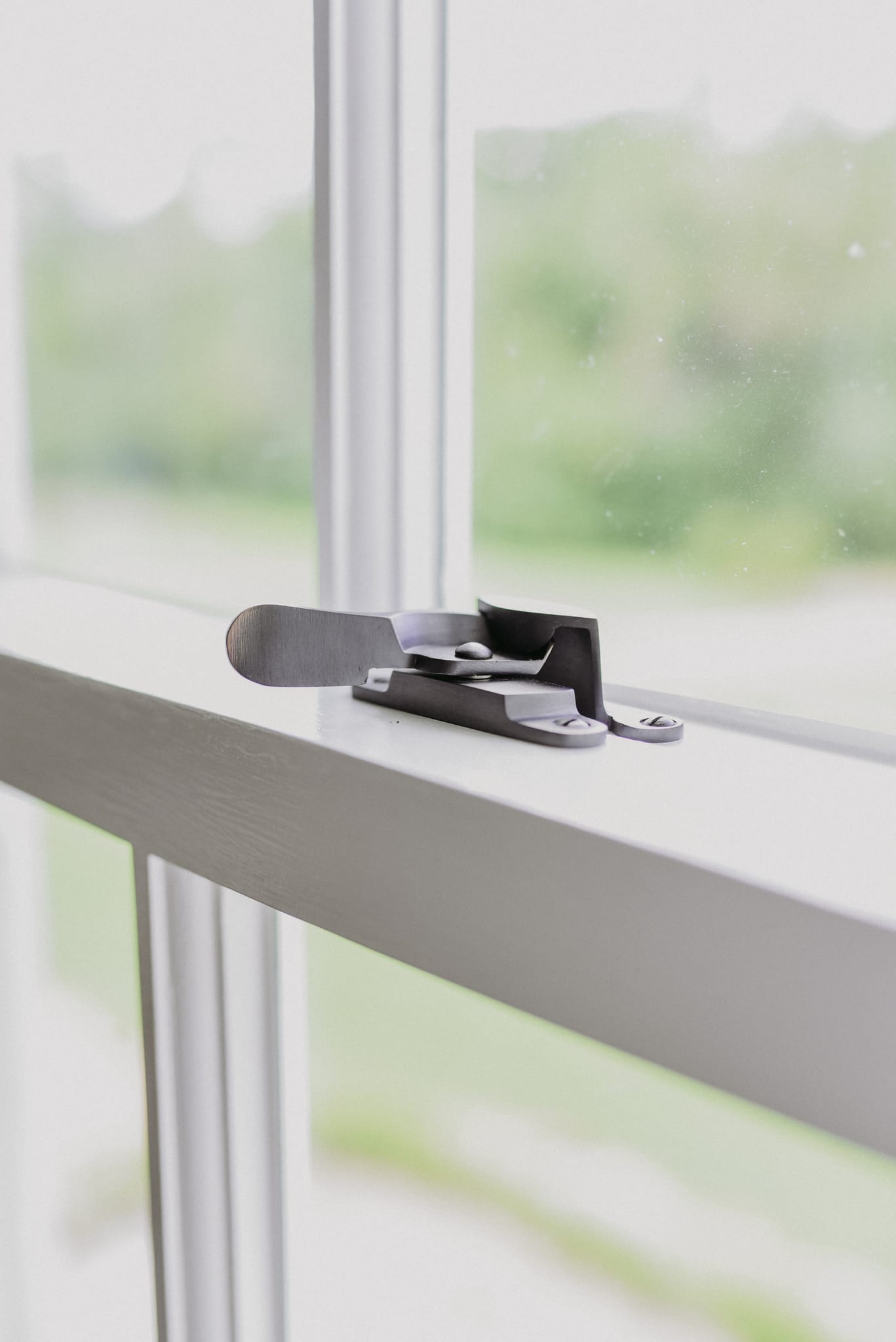 Sash fastener on the meeting rail of a white timber sash window