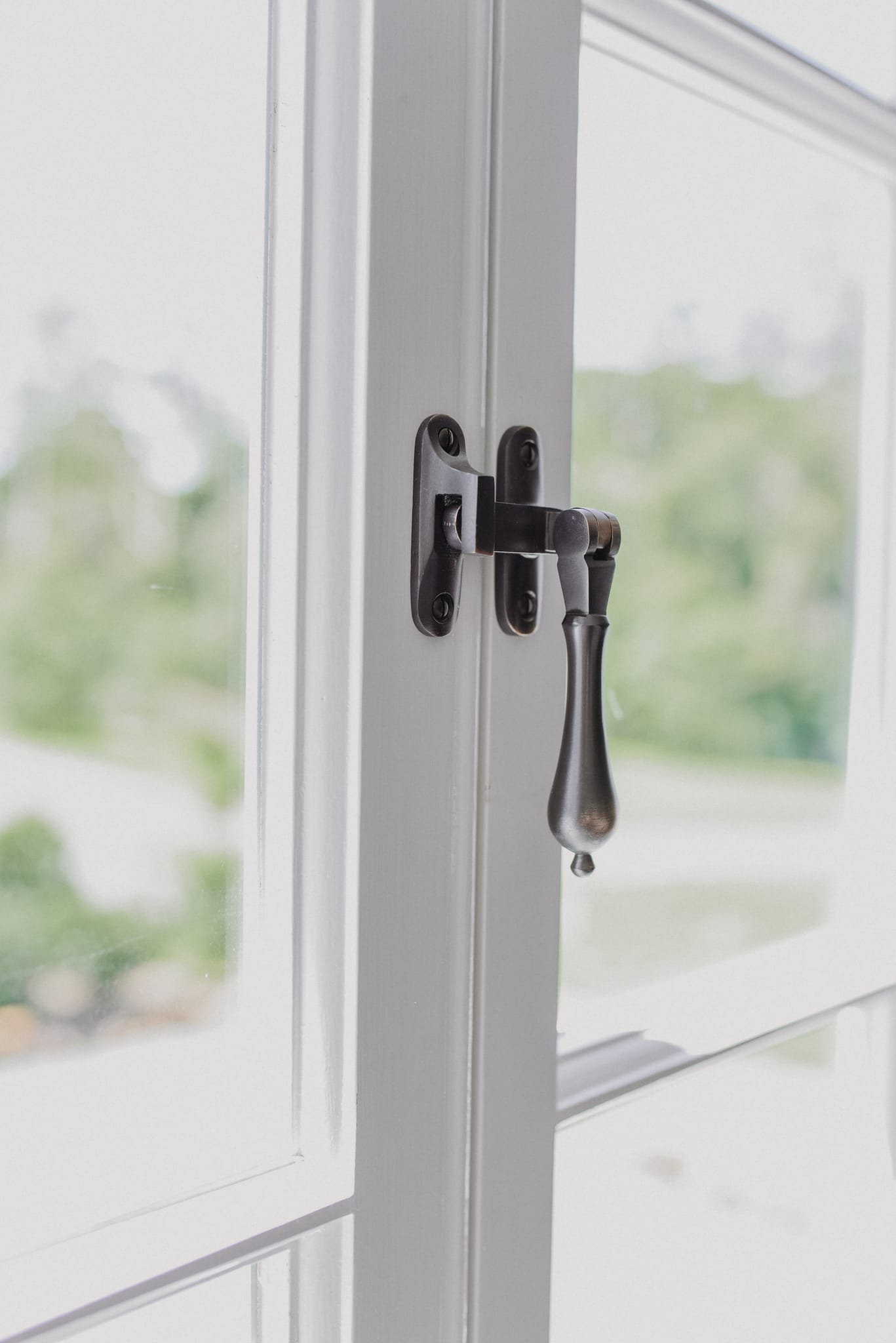 Casement fastener on a closed white timber casement window
