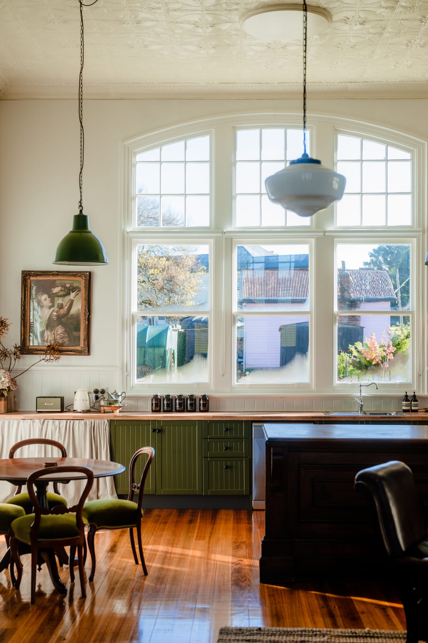 Kitchen with arched double-hung sash windows, pendant lights and timber floors at The Post Office